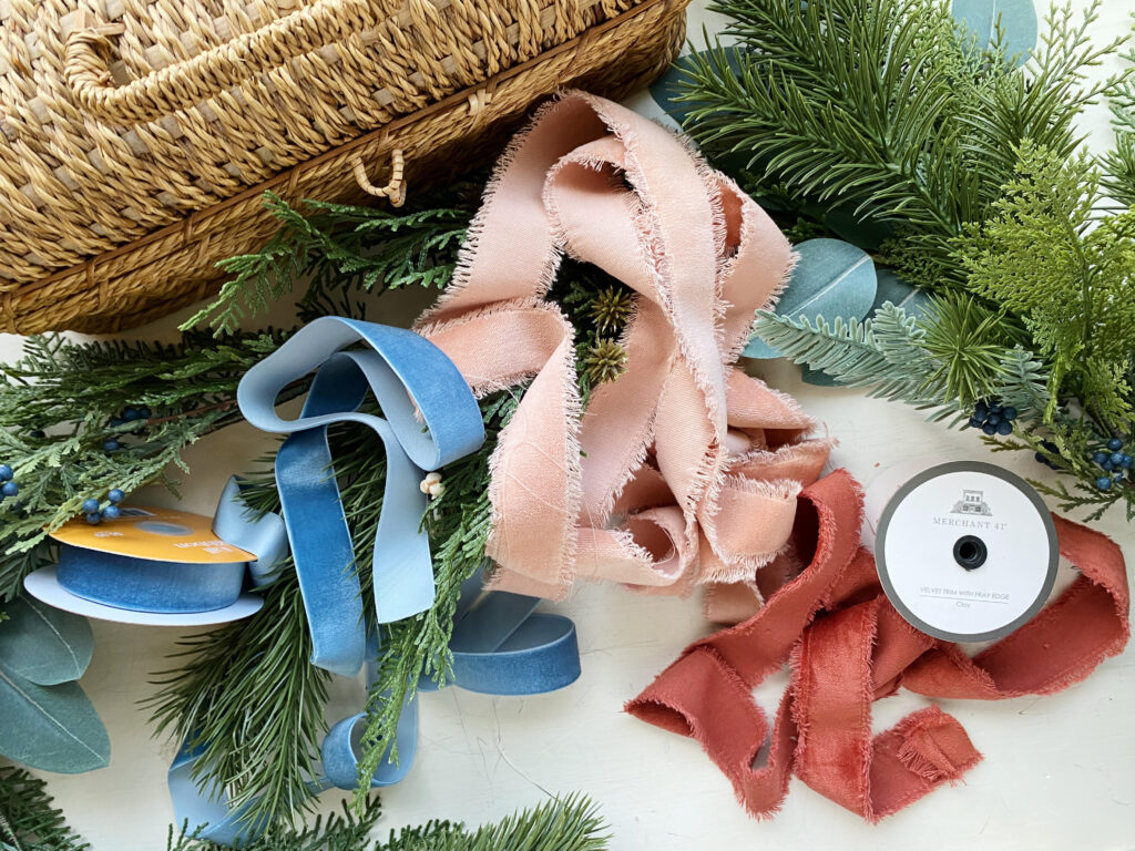 Blue, pink, red velvet ribbon with Christmas greenery. 